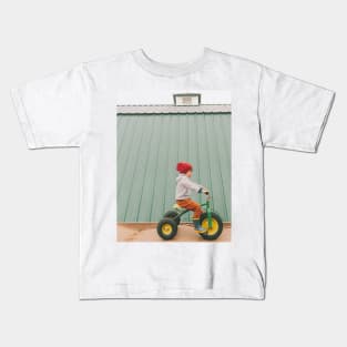 a child on a bicycle Kids T-Shirt